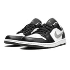 Black and white sneakers with a brand logo on a white background